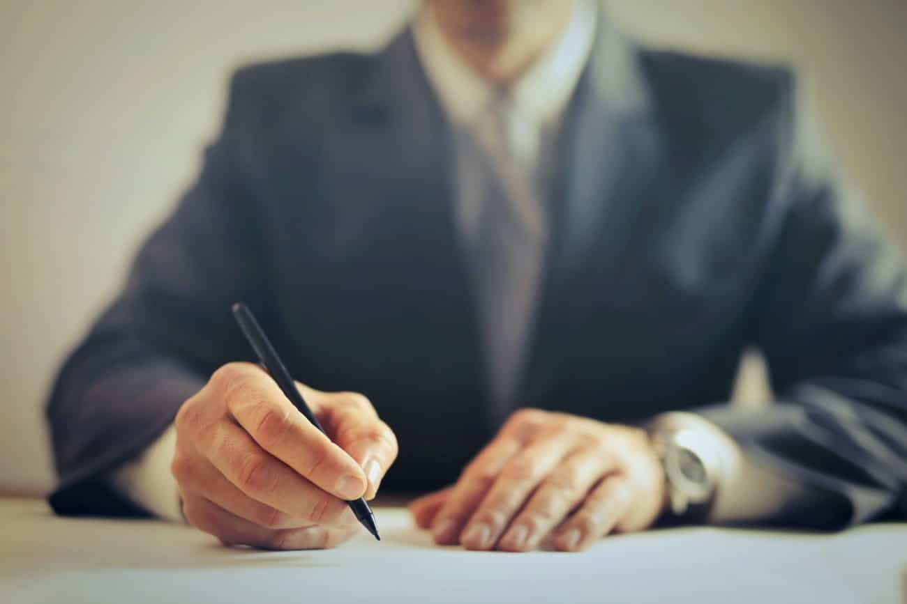 Product manager writing on paper with pen